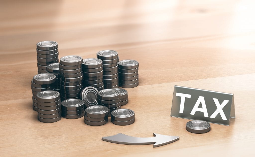 Stacks of coins and tax sign