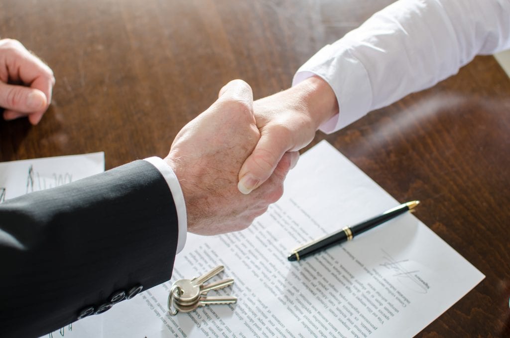 Business handshake over signed documents